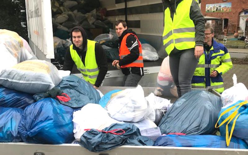 Helfer beim Packen von Altkleidersäcken